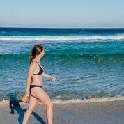 Woman on beach with Sensitive sunscreen lotion SPF 50 by We are Feel Good Inc