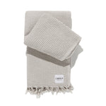 folded waffle family beach blanket in sand