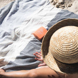Child sitting on Ozoola Johnny Turkish beach towel in natural 