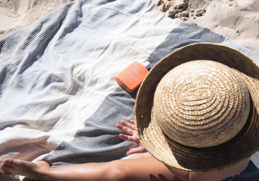 Child sitting on Ozoola Johnny Turkish beach towel in natural 