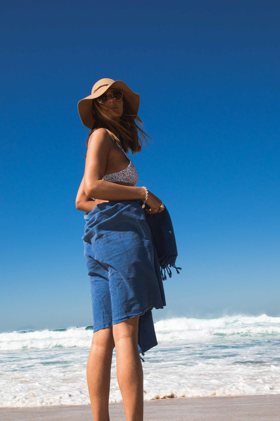 Woman on beach with Ozoola Turkish beach towel in blue stonewash
