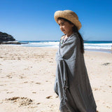 Child on beach wrapped in Ozoola Turkish beach towel