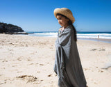 Child on beach wrapped in Ozoola Turkish beach towel